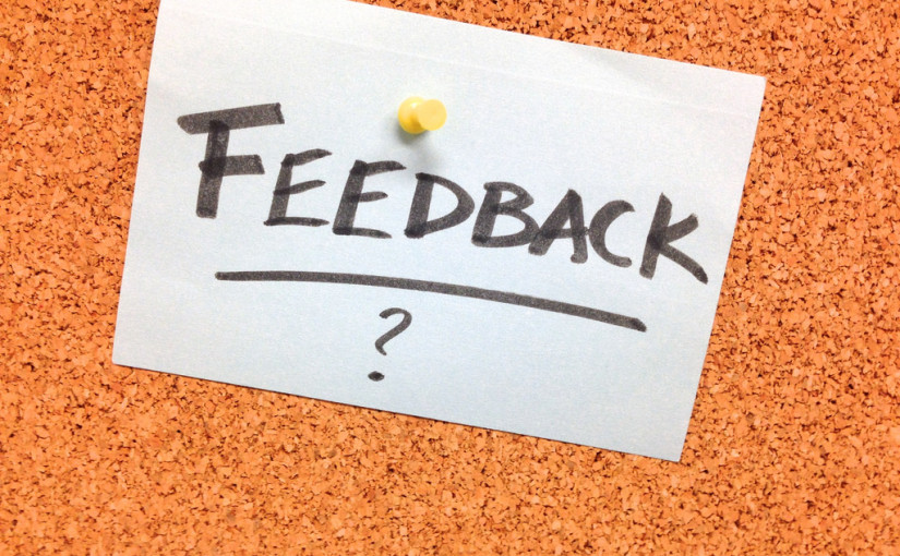 photo of notecard pinned to corkboard with the word feedback written on it
